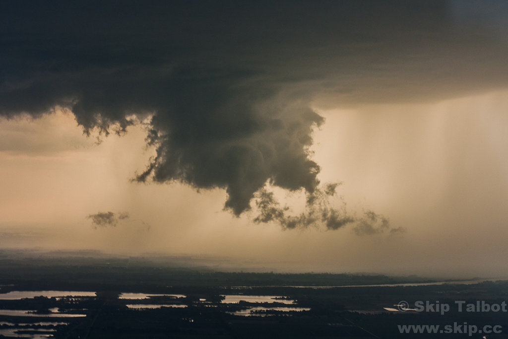 A wall cloud beneath a supercell thunderstorm, photographed from an airplane