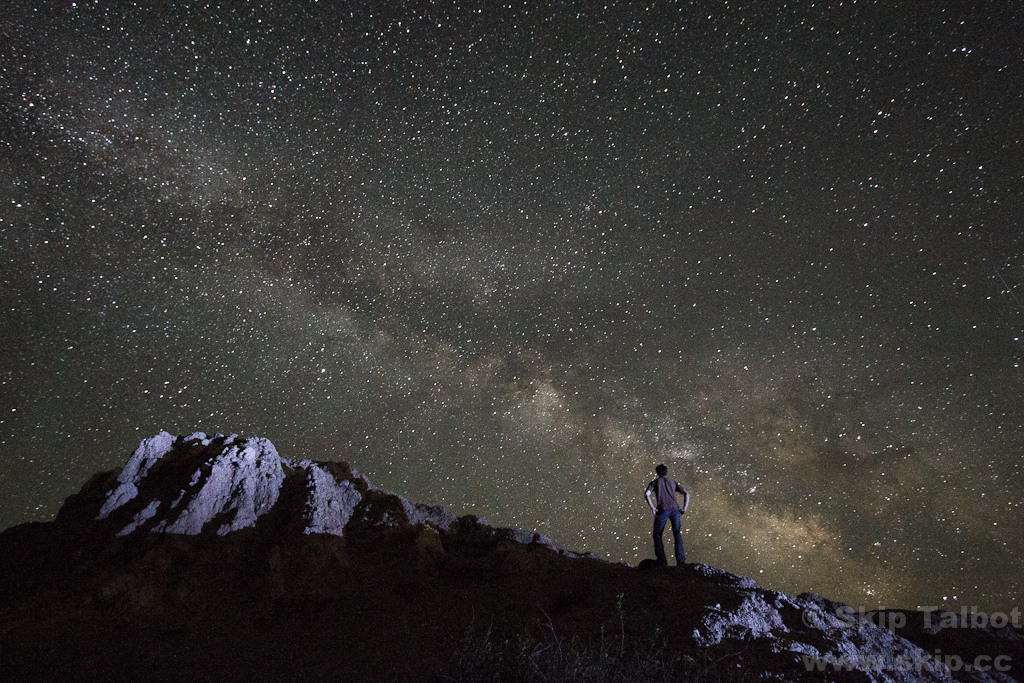 A curious stargazer stands atop the Badlands, watching the Milk Way
