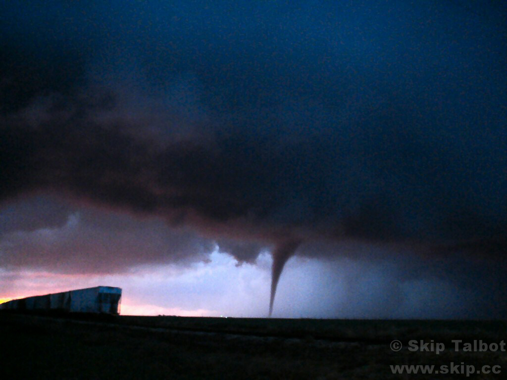 A tornado backlit by the setting sun